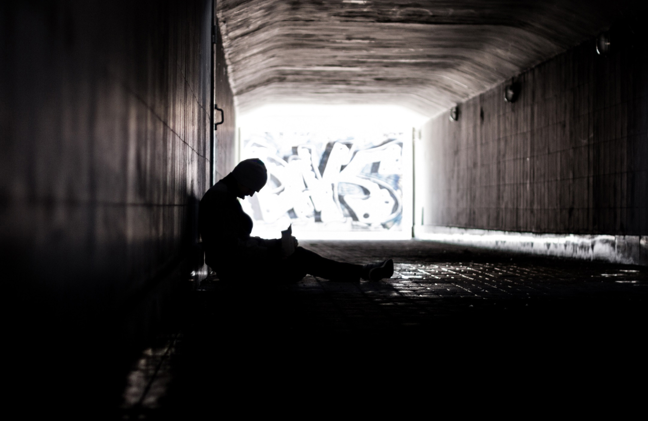 a person sitting in a dark tunnel