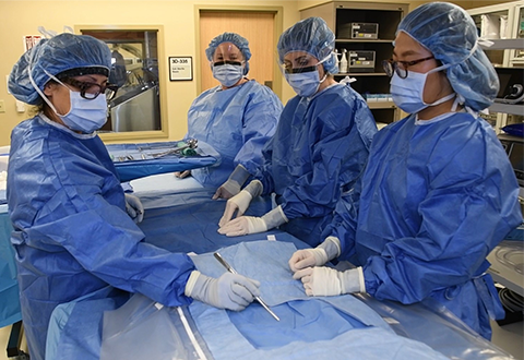 Former nurse practitioner (NP) residents refresh skills while working with surgical instruments in an operating room training environment at the New Mexico VA Healthcare System.