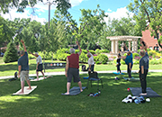 Veterans practice yoga poses outside in a garden
