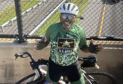 Man poses on bridge in front of his sports bike.