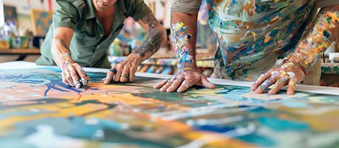 a close-up image of a veteran and a therapist working on a large community mural, showcasing the collaborative and therapeutic aspects of art therapy, Memorial Day, Independence Day, 4th july